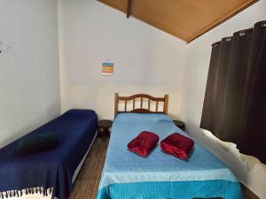 a bedroom with two beds with blue and red sheets at Chalés Pão Sobre as Águas - a 5 minutos de cachoeiras e vista maravilhosa do pôr do sol in Carrancas
