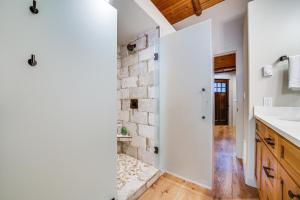 a kitchen with white walls and a brick wall at Contemporary Log Cabin Near Cle Elum Lake! in Driftwood Acres +20 photos