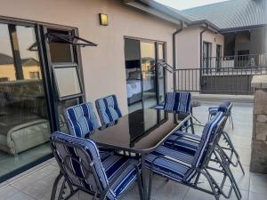 una mesa y sillas en un patio con balcón en Aurora Executive Stay In Waterfall City, en Midrand