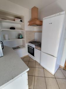 a kitchen with a white refrigerator and a stove at F5 à Montjaux in Montjaux