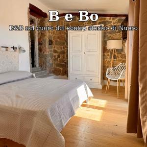 a bedroom with a bed and a chair in a room at B e Bo in Nuoro