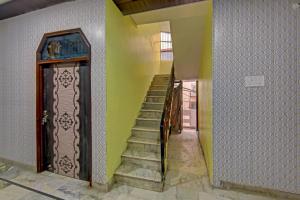 a staircase in a house with a green wall at Hotel O Cozy Cottage in Meerut