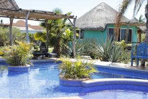 a resort with a swimming pool with a house at Hotel ecoturístico Casitas el Salitral in El Pescadero