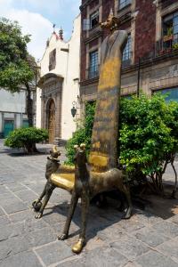 une statue de deux animaux assis sur un banc dans l'établissement Experience the Magic of the Historic Center from Your Own Balcony, à Mexico