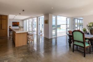 eine Küche und ein Esszimmer mit Tisch und Stühlen in der Unterkunft Onetangi Estate by Waiheke Pure in Waiheke Island