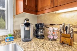a coffeemaker sitting on a kitchen counter next to a sink at Alluring Desert Haven in La Quinta #A in La Quinta