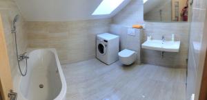 W łazience znajduje się umywalka, toaleta i wanna. w obiekcie Villa Marcus w mieście Pasohlávky
