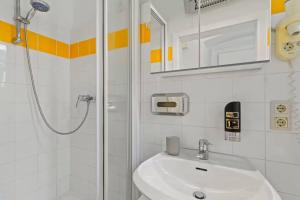 a white bathroom with a sink and a shower at Art Hotel Vienna in Vienna +98 photos