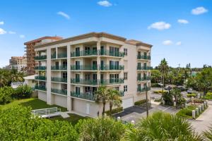 an apartment building with balconies and a parking lot at Flores Ocean Suites 402 in Cape Canaveral
