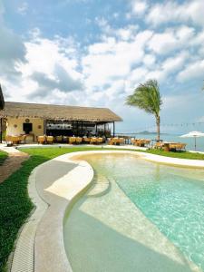 a swimming pool in front of a house with the ocean at Azul Beach Resort and Restaurant in Bophut 