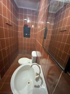 a bathroom with a toilet and a sink at Hotel Pompéia em Almeirim  +14 photos