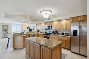 a large kitchen with wooden cabinets and stainless steel appliances at Michelina 406 in Cape Canaveral