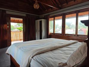 Un dormitorio con una cama grande en una habitación con ventanas. en Juna Bungalow, en Gili Air
