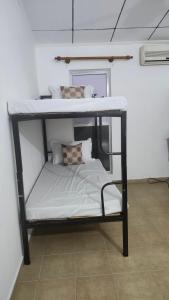 a bunk bed with white sheets and pillows on it at Sapphire Homestay in Dehiwala
