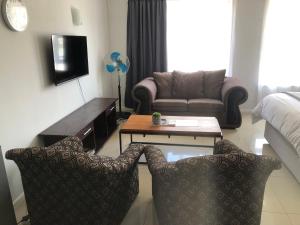 a living room with a couch and a table and chairs at Relaxing Hideaway in Strand