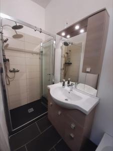 Un baño con lavabo, ducha y espejo. en La Stella Bianca, en Sutri