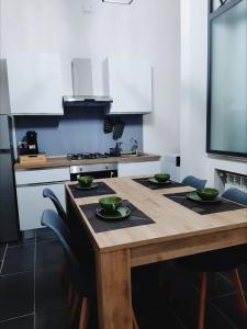 una cocina con una mesa de madera con tazones verdes. en La Stella Bianca, en Sutri