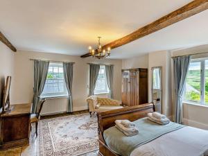 a bedroom with two beds and a desk and windows at 9 Bed in Hay-on-Wye 73069 in Painscastle