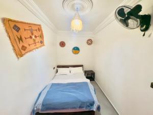 - une petite chambre avec un lit et un lustre dans l'établissement Jada surf hostel, à Taghazout