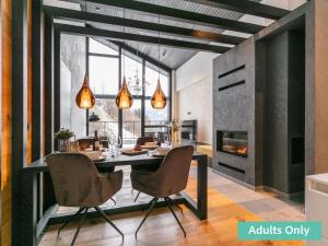a dining room with a table and chairs and a fireplace at Adult Only Superior Suite in Niederhof