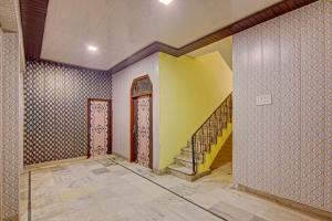 a hallway with a yellow wall and a yellow door at Hotel O Cozy Cottage in Meerut
