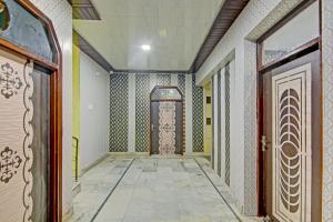 a hallway with a door and a tile floor at Hotel O Cozy Cottage in Meerut