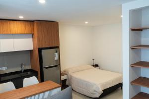 マル・デル・プラタにあるLoft amplio y moderno a 2 cuadras del mar calidad superiorのベッドとキッチンのある小さな部屋