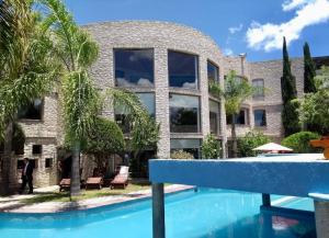 a house with a swimming pool in front of a building at Casa Diamante Hotel Boutique - Mineral de Pozos in Mineral de Pozos
