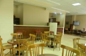 a dining room with tables and chairs and a kitchen at Bormali Hotel in Corlu