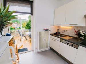 een keuken met witte kasten en een raam met een terras bij Hubertus II in Bad Pyrmont