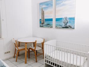 een babykamer met een kinderbedje, een tafel en stoelen bij Hubertus II in Bad Pyrmont