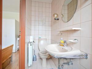 Un baño con inodoro, lavabo y espejo. en Bärenhöhle, en Marktleuthen