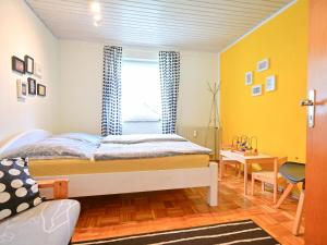 Un dormitorio con una cama y una pared amarilla. en Bärenhöhle, en Marktleuthen
