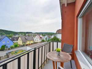 a balcony with a table and a view of a town at Bärenhöhle in Marktleuthen