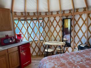 a room with a bed and a table and chairs at Mountain Aire Cottages, Inn & Glamping in Clayton