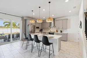 a kitchen with a large island with bar stools at Beachside Deluxe in Melbourne Beach