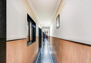 an empty hallway in a building with wooden floors and windows at Hotel O Rourkela Palace in Raghunāthpāli