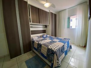 una camera con un letto con una coperta blu e bianca di Espaço Prisco a Praia Grande