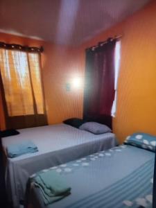 Dos camas en una habitación pequeña con ventanas. en Nuestra Casita Apartamento Rinconcito Familiar, 
