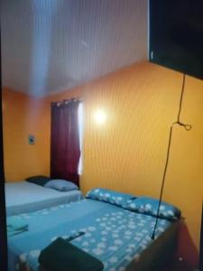 Un dormitorio con dos camas y una pared amarilla. en Nuestra Casita Apartamento Rinconcito Familiar, 