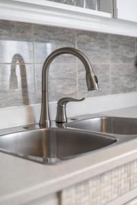 a stainless steel sink in a kitchen at Cozy Family Home Near Montreal in Brossard +47 photos