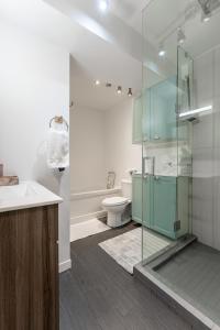 a bathroom with a glass shower and a toilet at Cozy Family Home Near Montreal in Brossard