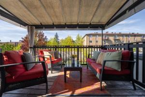 a patio with red chairs and a table on a balcony at Cozy Family Home Near Montreal in Brossard