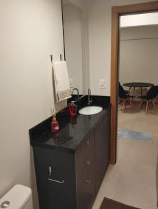 a bathroom with a black counter with a sink at Apartment in the center 500 meters from Proeb in Blumenau