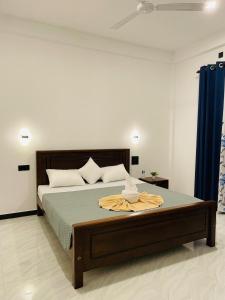 a bedroom with a large bed with a blue curtain at Geeth Wild Resort in Tanamalwila