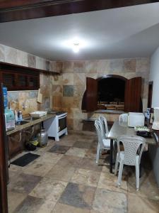 una cucina con un tavolo e sedie in una stanza di Casa Do Marcão a Camocim