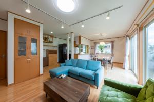 a living room with a blue couch and a table at GuestHouse　YOU&I in Fujikawaguchiko