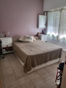 een slaapkamer met een bed, 2 drempels en een raam bij FLAT Fleming Martinez in Martínez