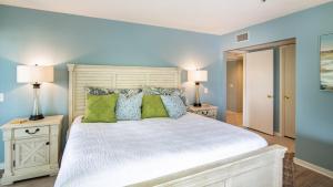 a bedroom with a large white bed with green pillows at Kingston Plantation - Laurel Court #112 - Seaclusion in Myrtle Beach +30 photos