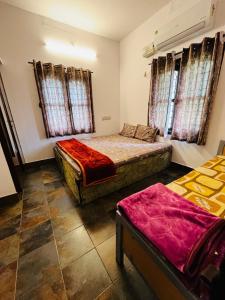 een slaapkamer met twee bedden en twee ramen bij Coastal Nest Home - Malpe Beach in Malpe